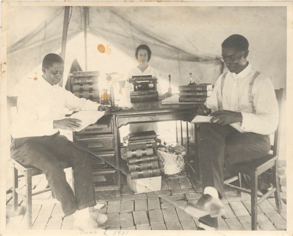 Phpto of a tent established as a legal office, attorney I. H. Spears, secretary Effie Thompson and B. C. Franklin