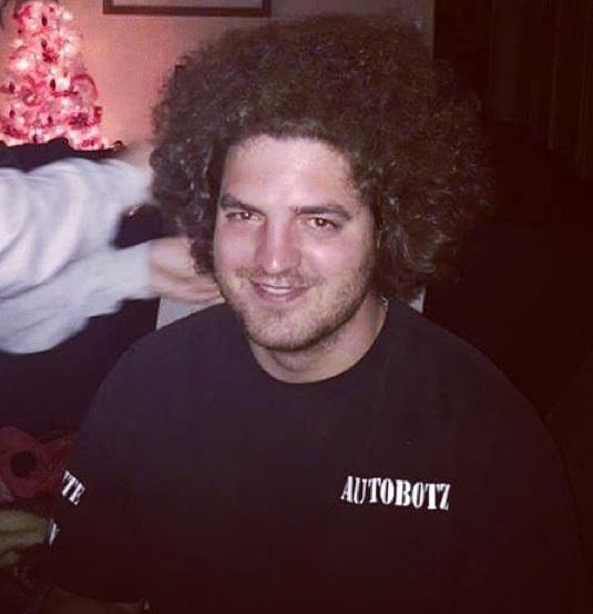 A-photograph-of-an-overweight-male-sporting-his-coiled-hair-as-a-Jewfro-hairstyle-with-a-long-curly-haircut.jpg